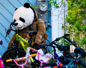 Un déguisement de panda devant une pile de vélos